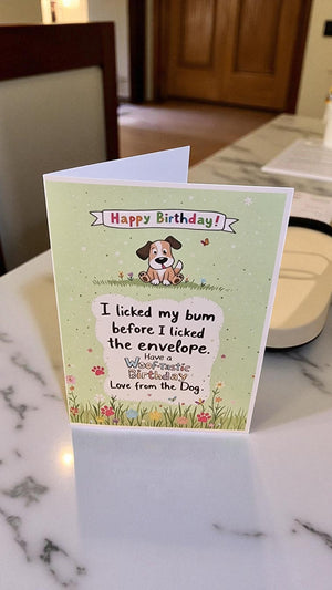 Birthday card with a dog illustration and humorous text on a marble surface.
