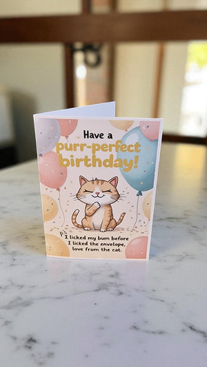 Birthday card with a cat illustration and text on a marble surface