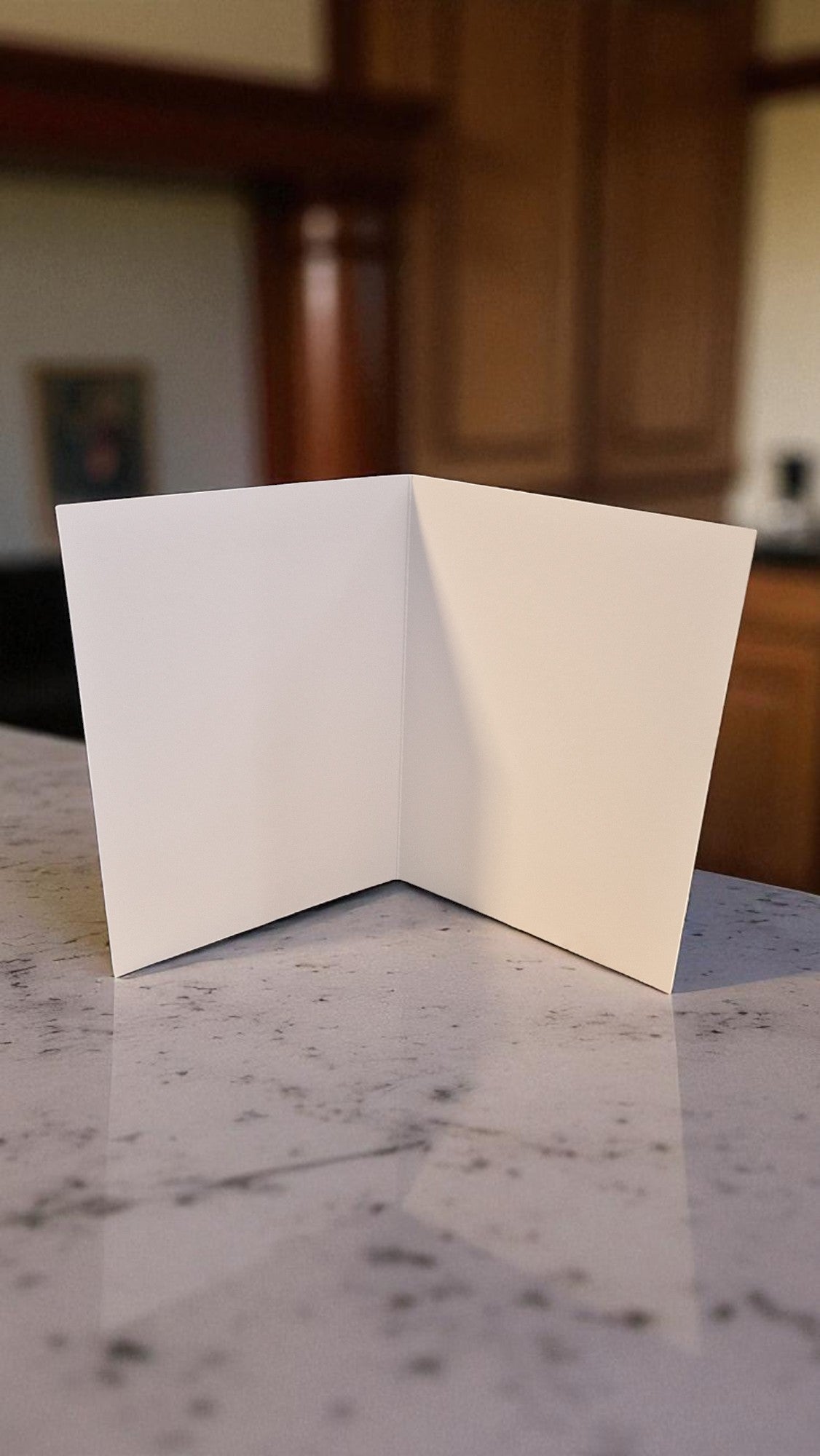 Open white card on a marble surface with a blurred background