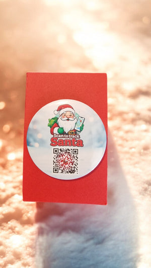 Red card with a Santa Claus sticker and QR code on a soft pink background