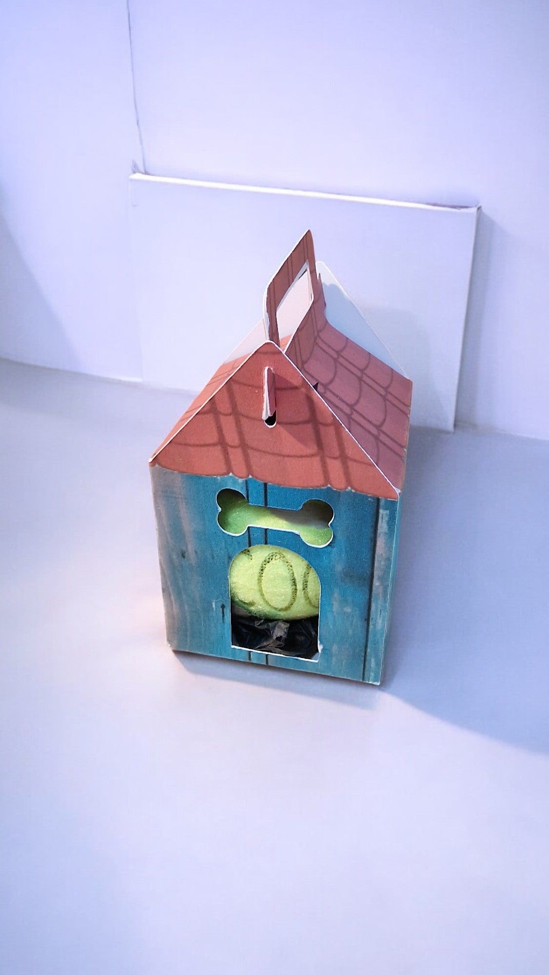 Wooden birdhouse with a green ball inside on a white background