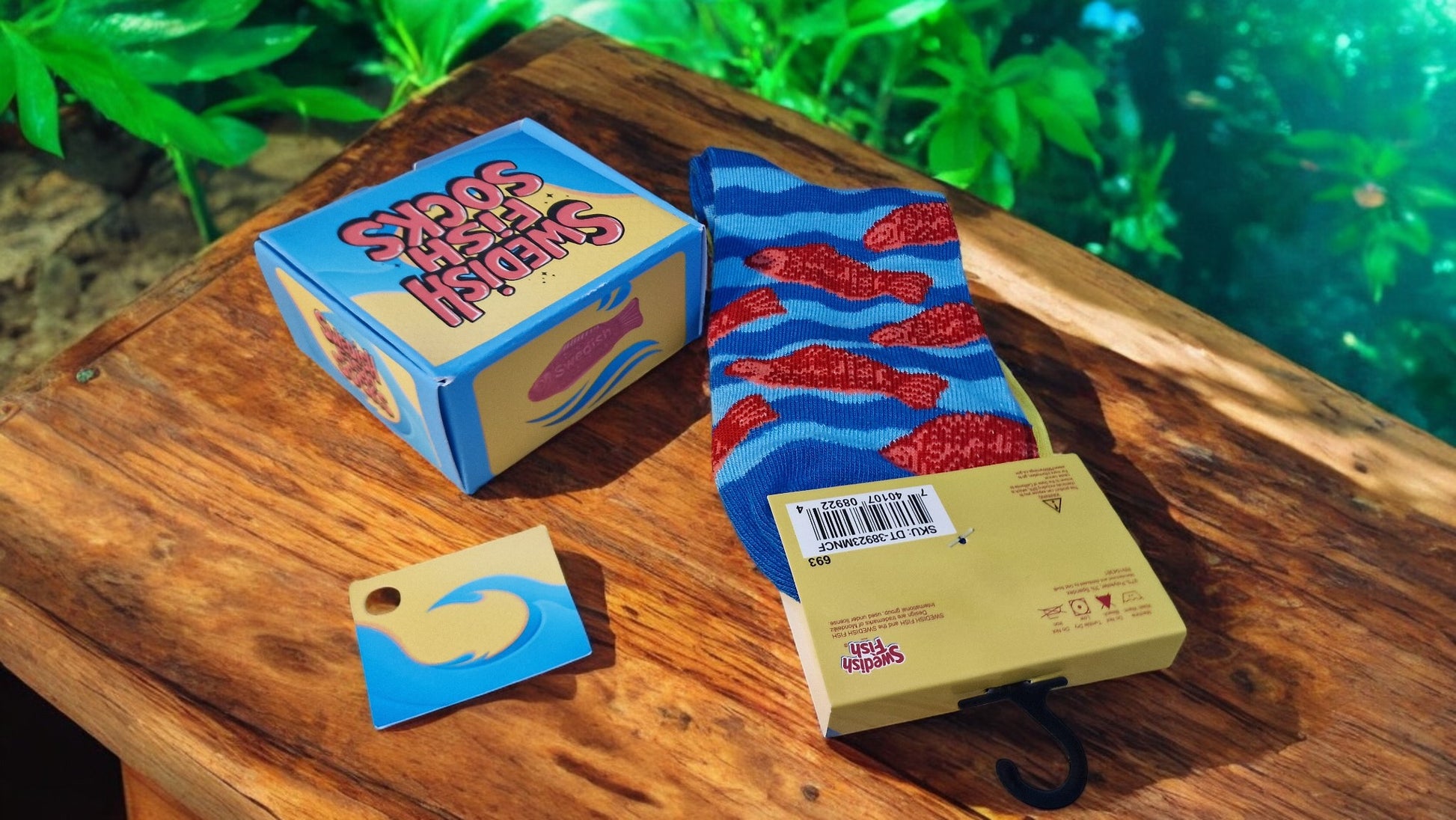 Socks with fish pattern on a wooden surface next to packaging