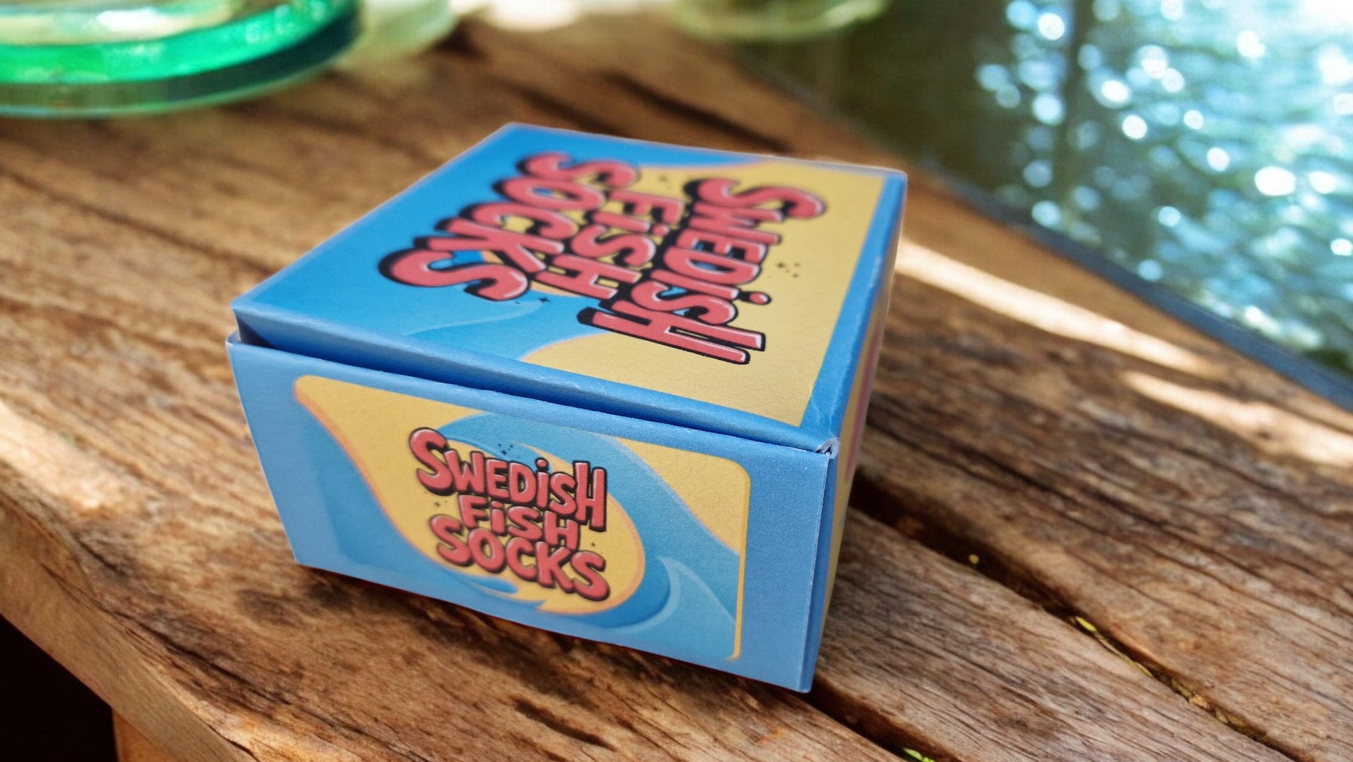 Swedish Fish socks and packaging on a wooden surface with neon lights in the background