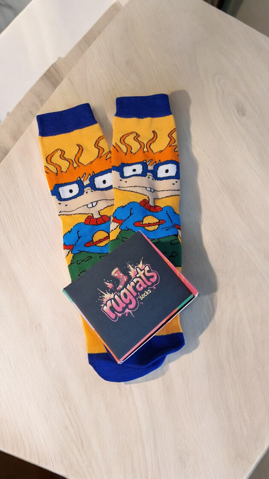 Colorful socks with cartoon design on a wooden surface