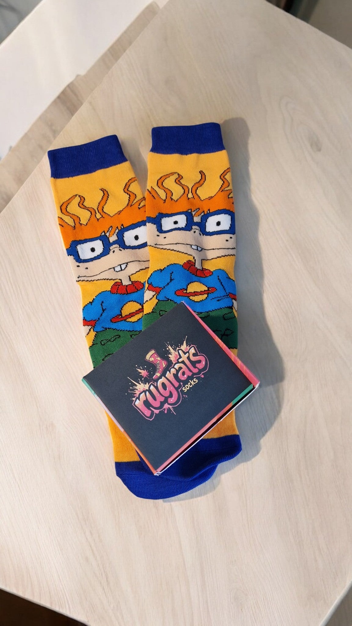 Colorful socks with cartoon design on a wooden surface