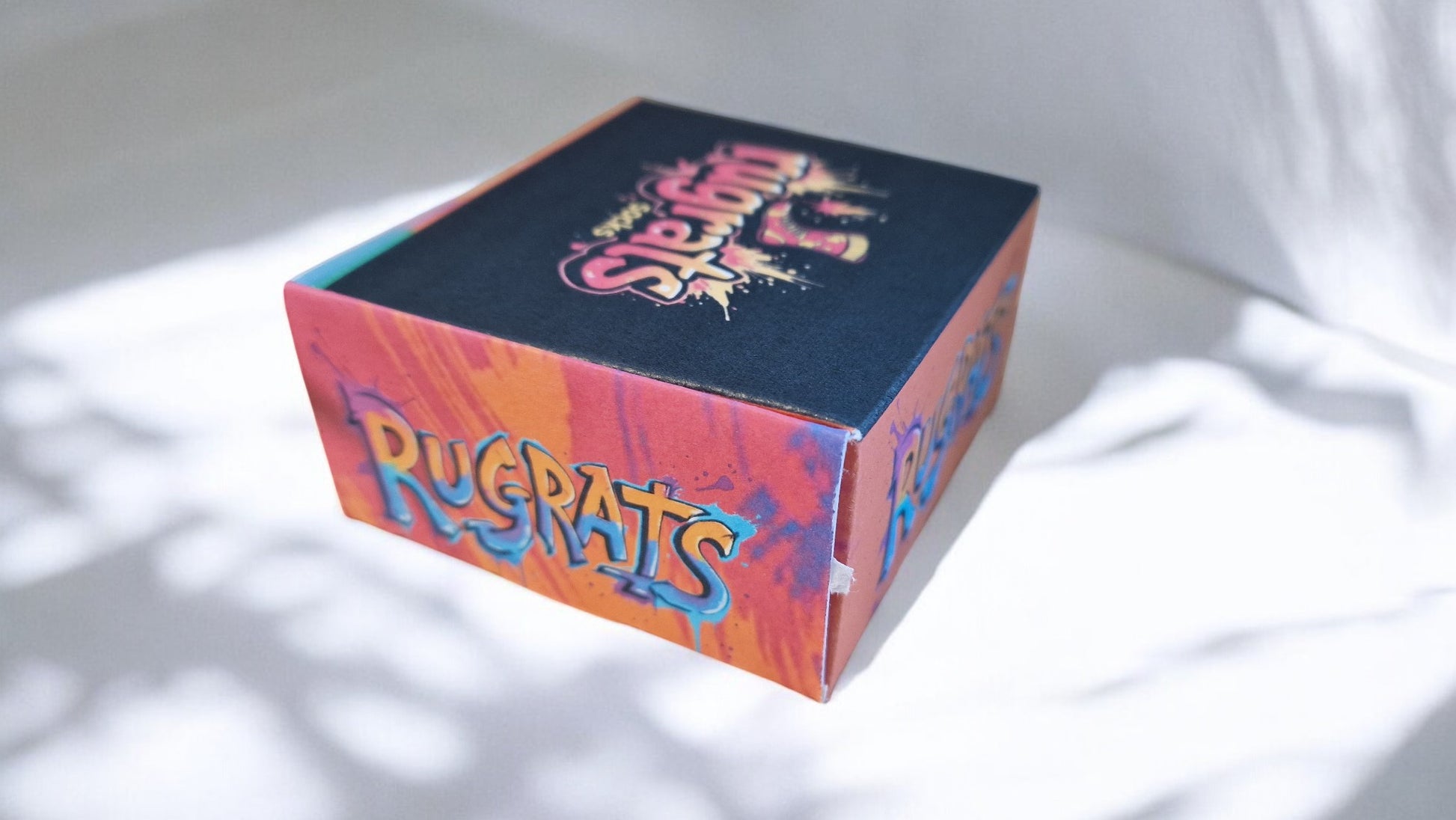 Colorful box with 'Rugrats' branding on a white background