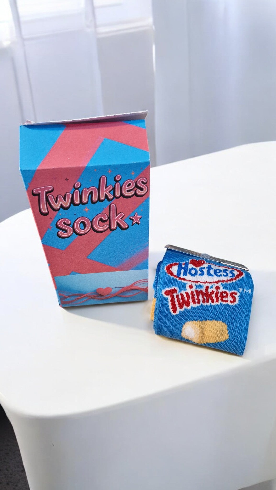Two packages of Hostess Twinkies on a white surface with a blurred background