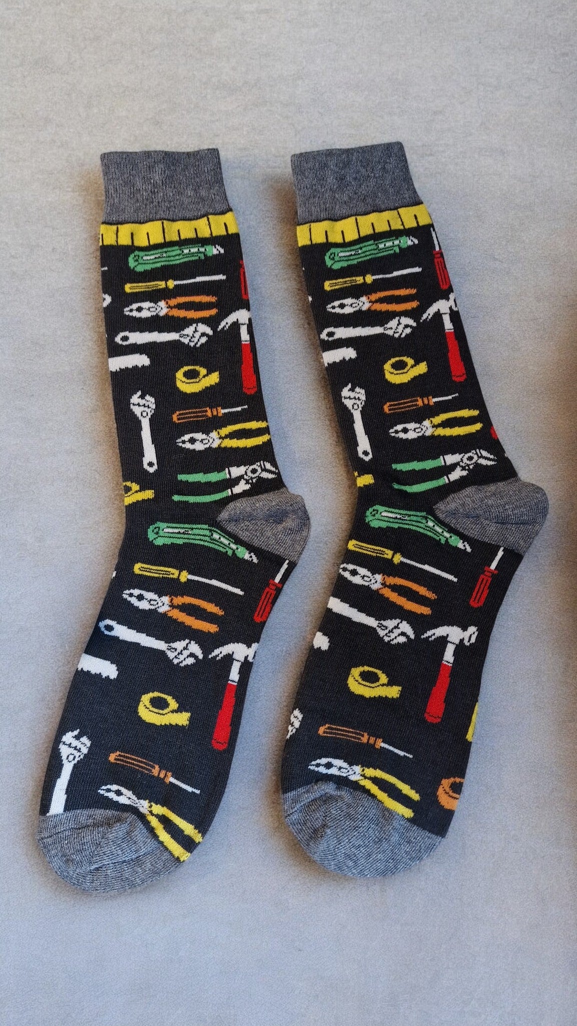 Pair of socks with tool pattern on a light gray background