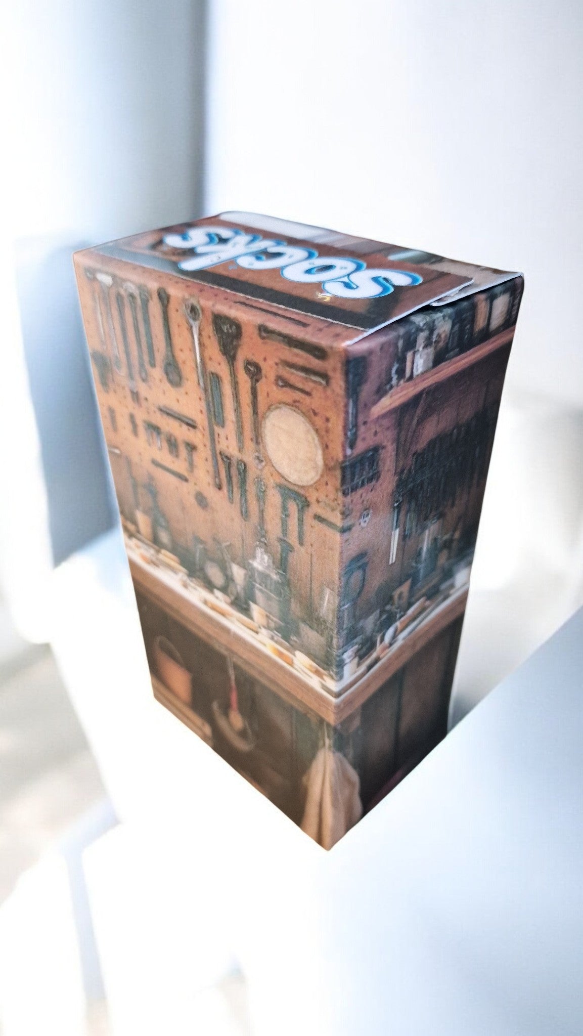 Cardboard box with intricate design and 'Topps' branding on a white background