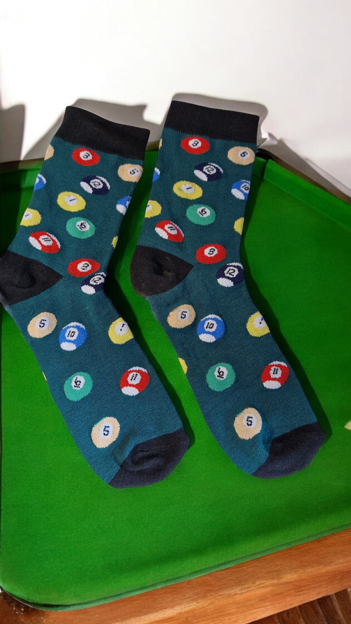 Pair of socks with billiard ball pattern on a green surface