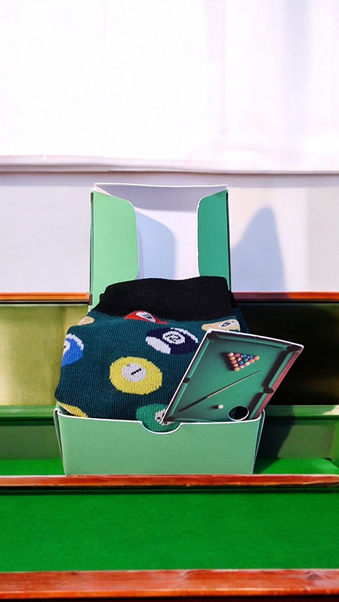 Miniature pool table with accessories on a green felt surface