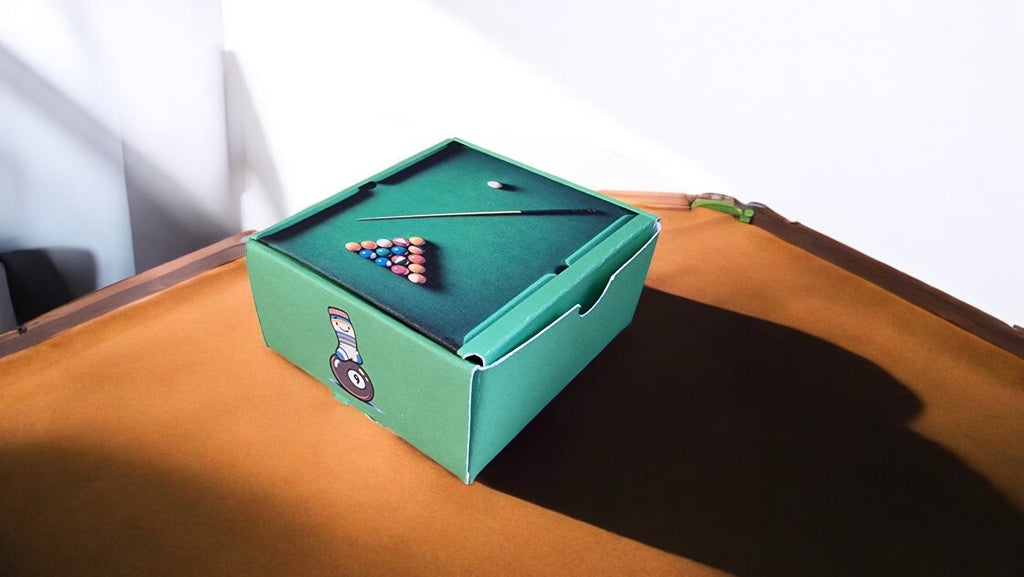 Miniature pool table with balls on a wooden surface