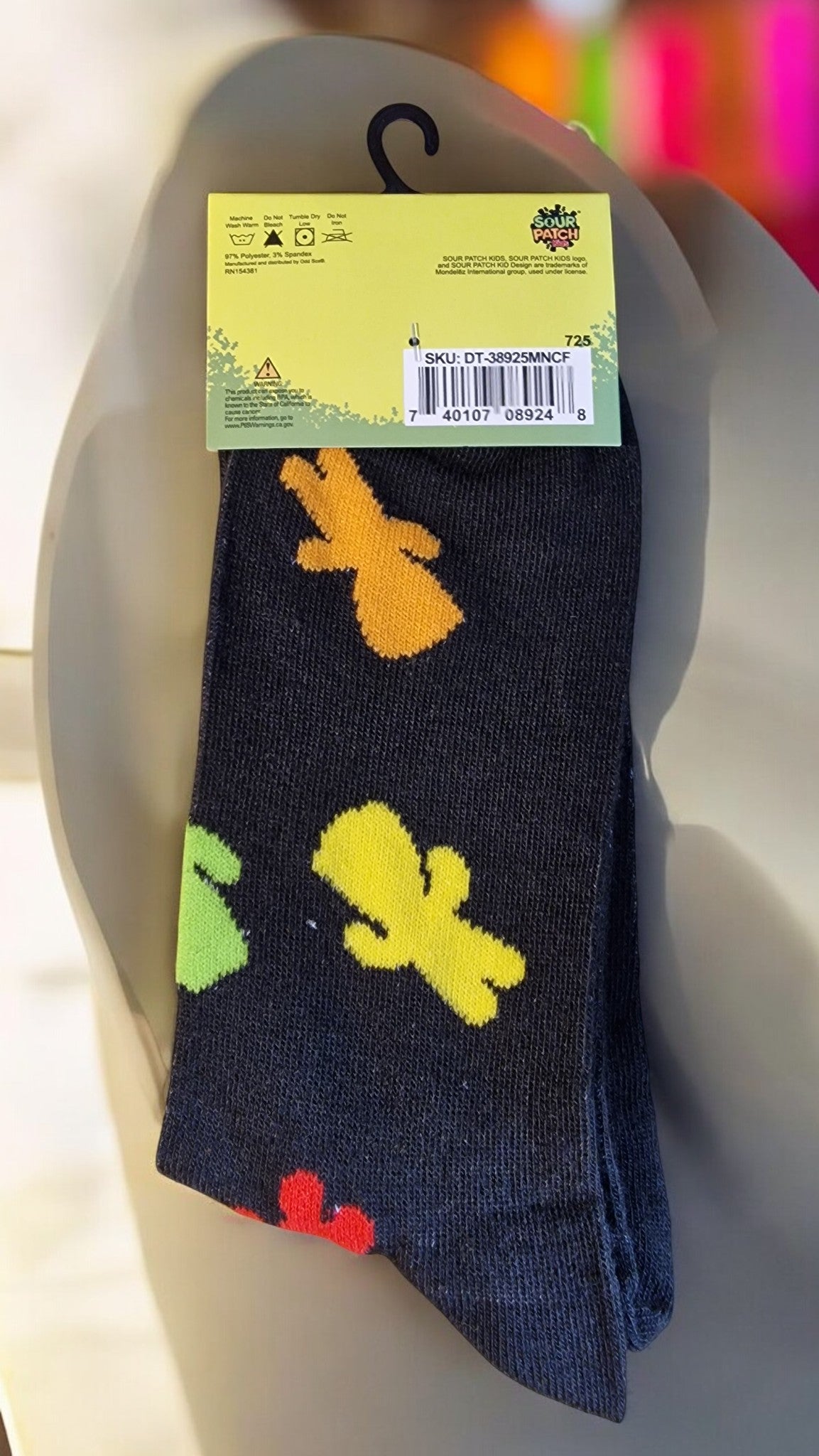 Black sock with colorful cactus patterns on a mannequin foot, with a visible brand label.