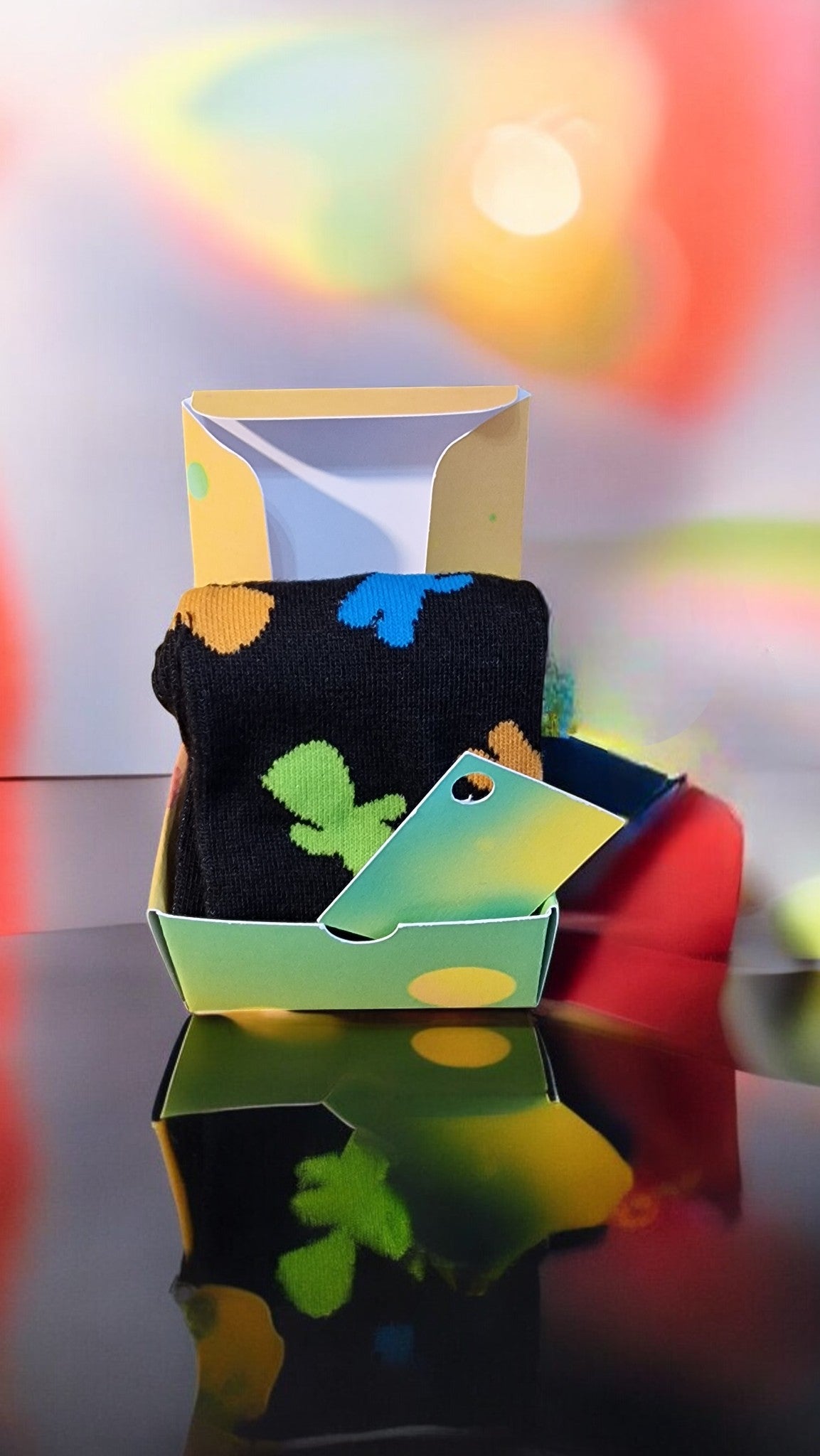 Colorful socks with leaf patterns in a box against a blurred multicolored background