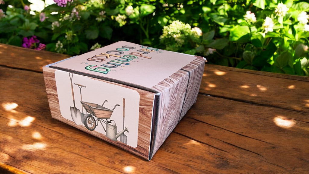 Cardboard box with gardening illustrations on a wooden surface with greenery in the background
