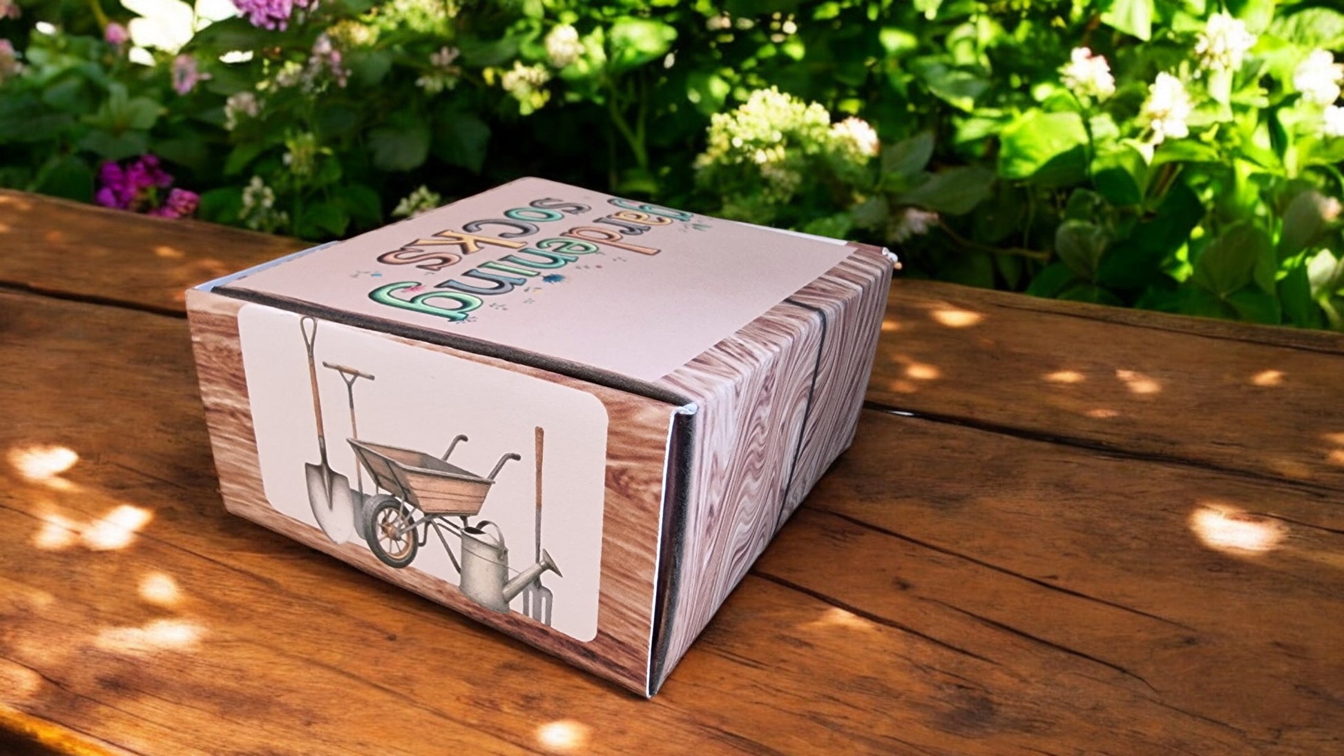 Cardboard box with gardening illustrations on a wooden surface with greenery in the background