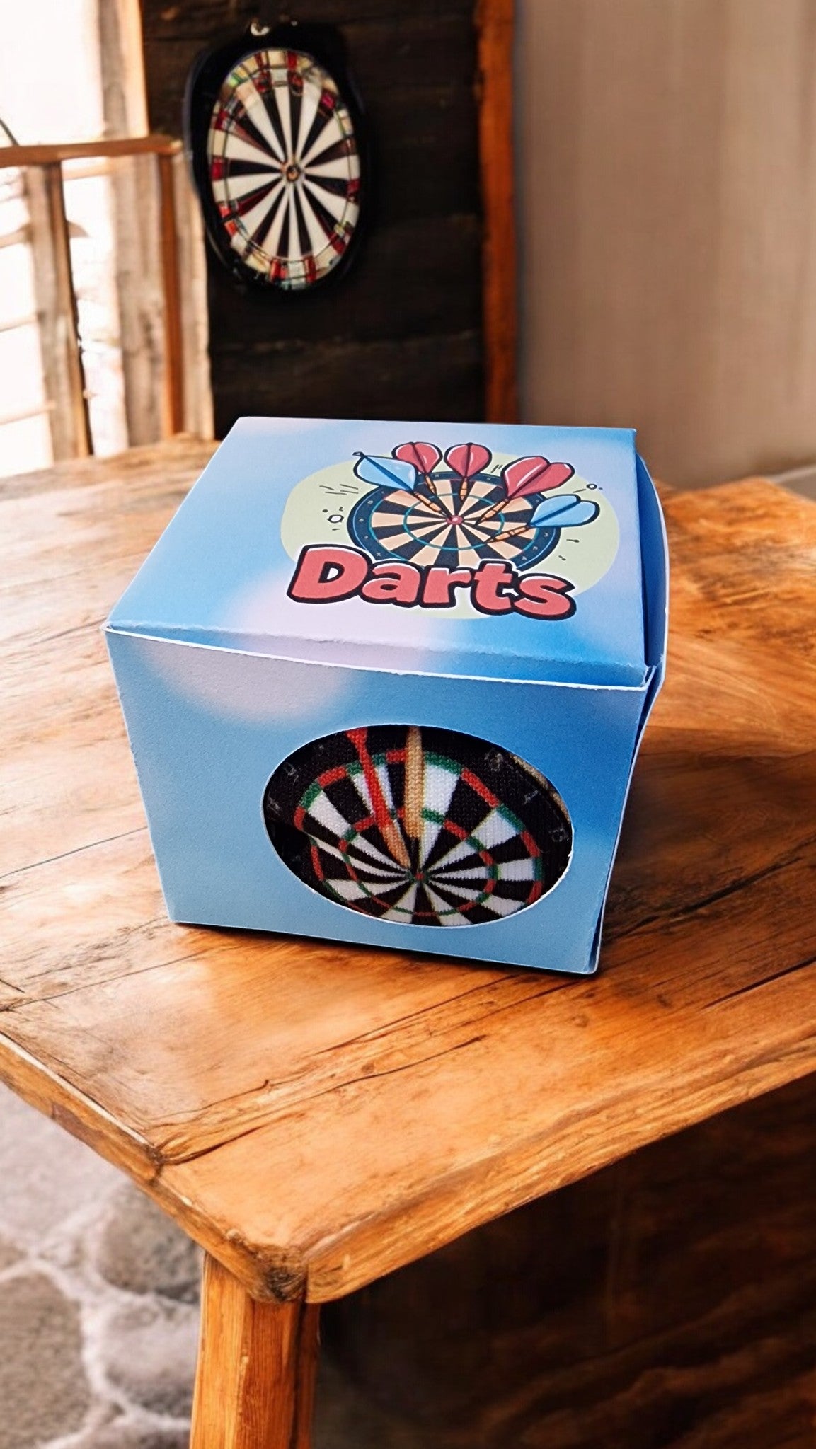 Blue dart box with a dartboard design on a wooden table