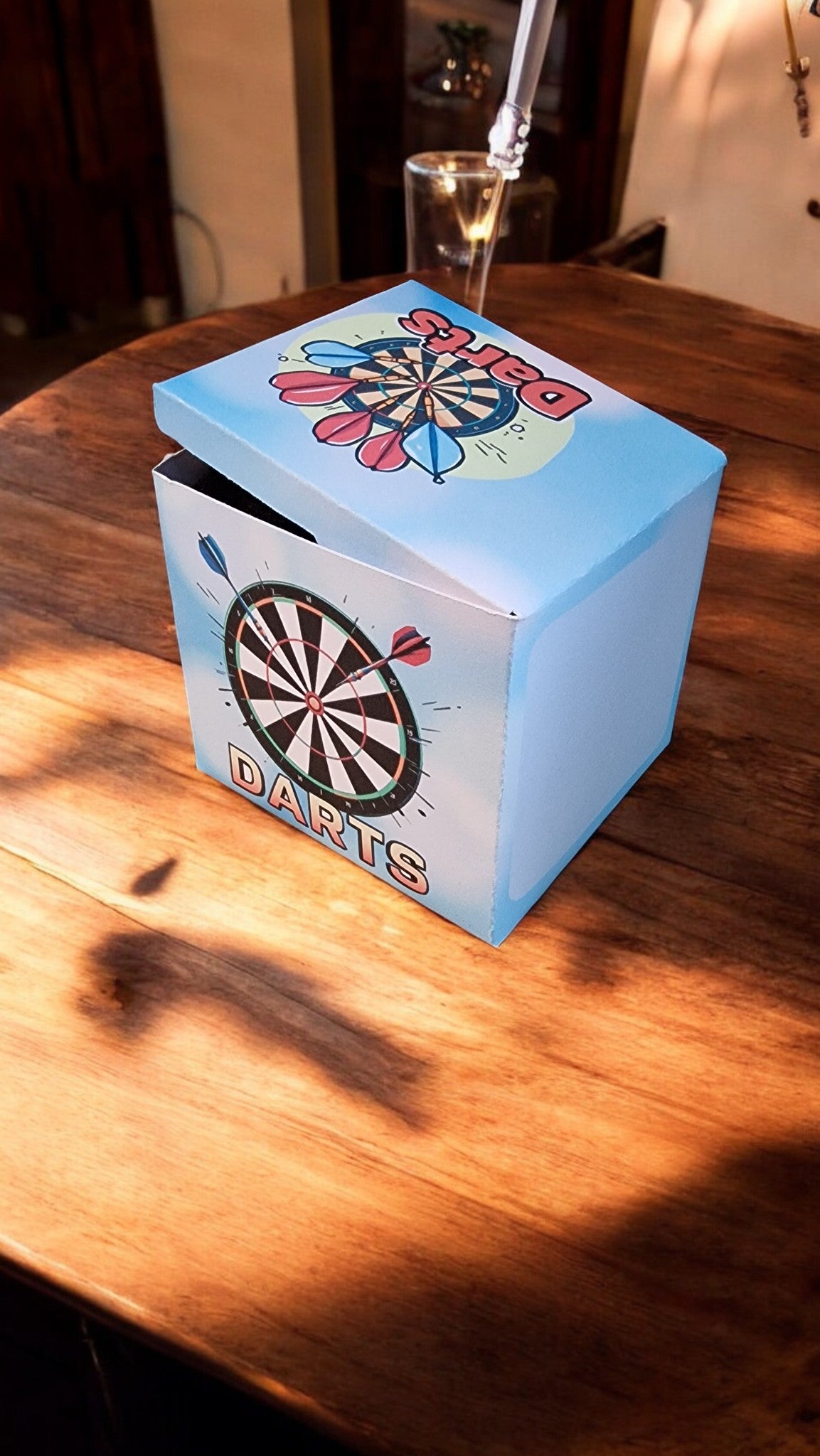 Blue dartboard-themed box on a wooden table