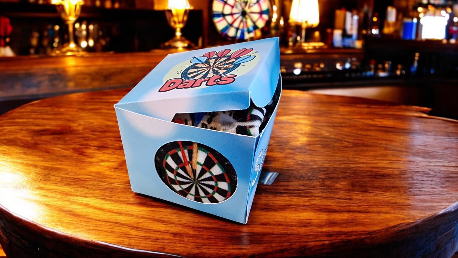 Box of darts on a bar counter with a dartboard in the background