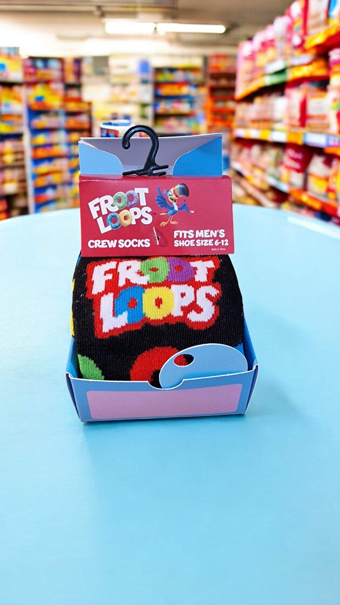 Froot Loops-themed socks in a packaging display with a store background.