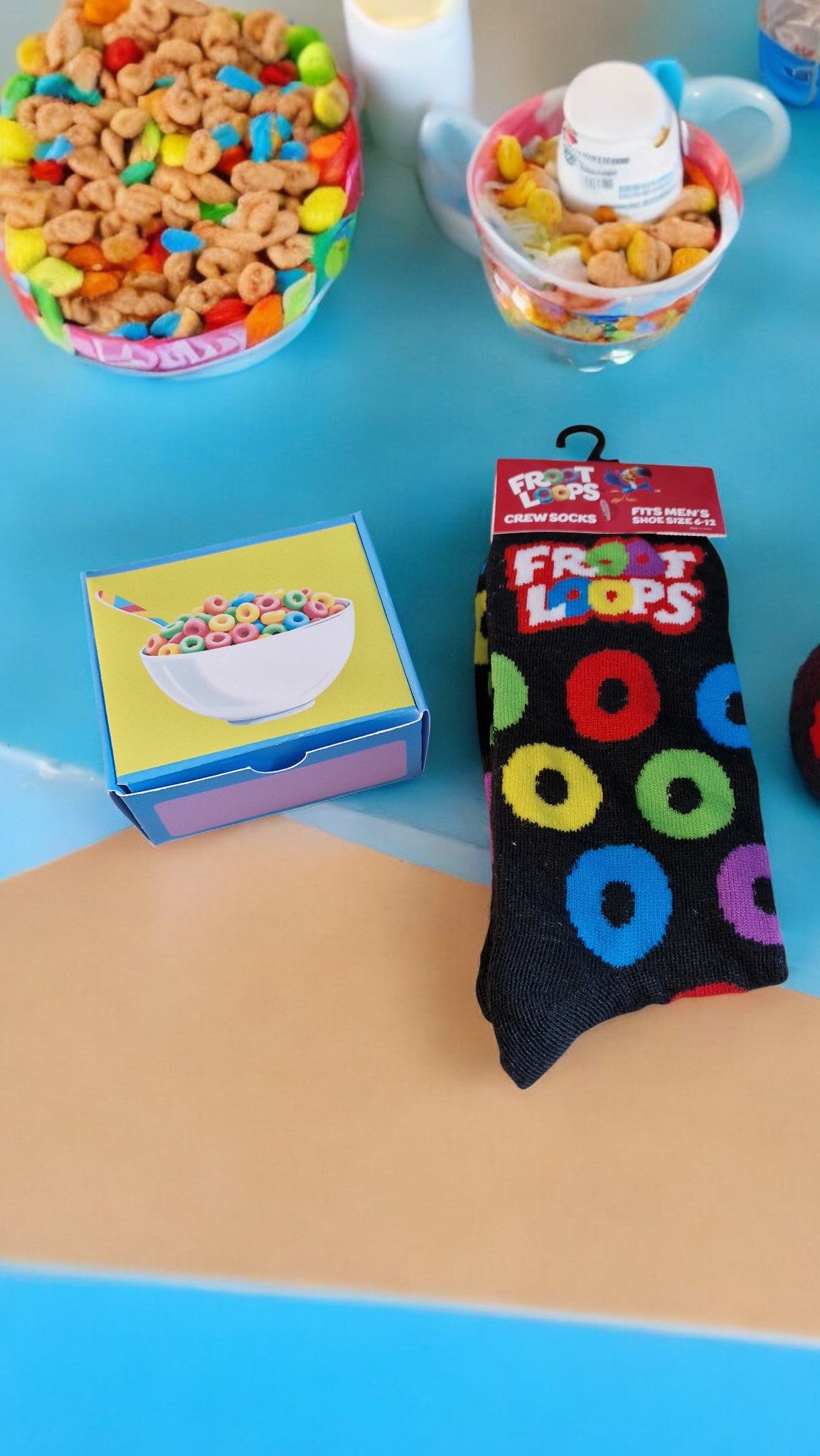 Colorful Froot Loops cereal in bowls with a matching sock on a blue surface