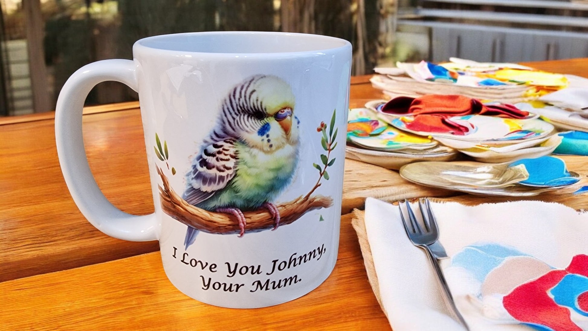Mug with a parrot design and text on a table with plates and cutlery