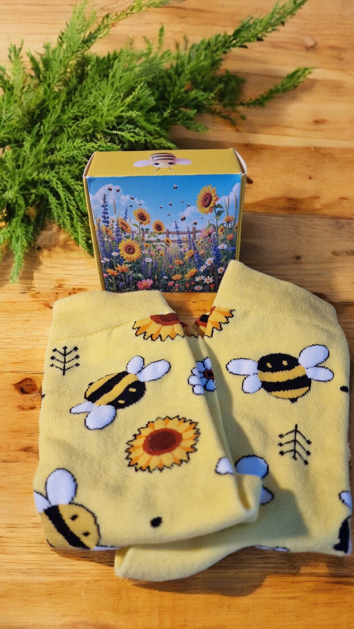 Yellow towel with bee and sunflower patterns on a wooden surface