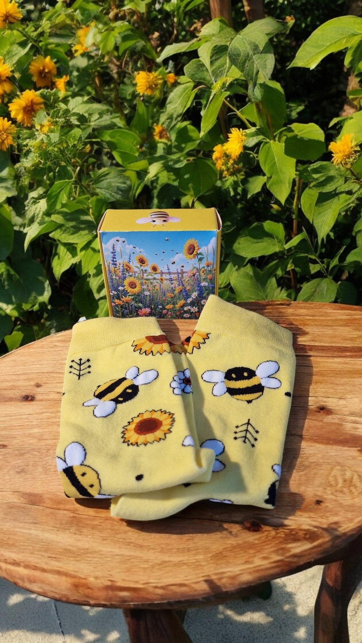 Yellow fabric with bee and sunflower pattern on a wooden table outdoors.