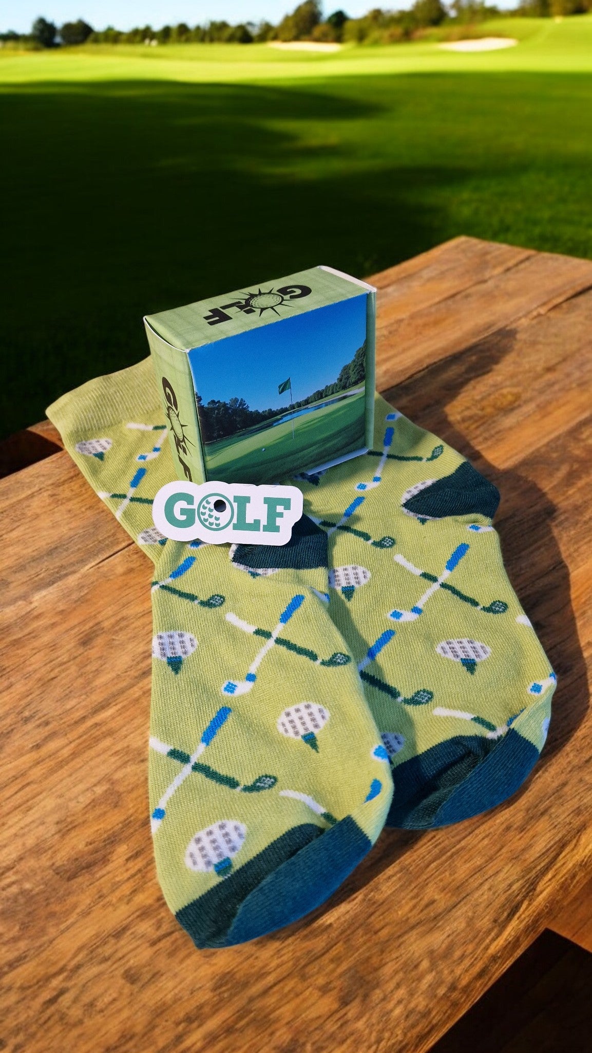 Golf-themed socks with a box on a wooden surface, golf course in the background