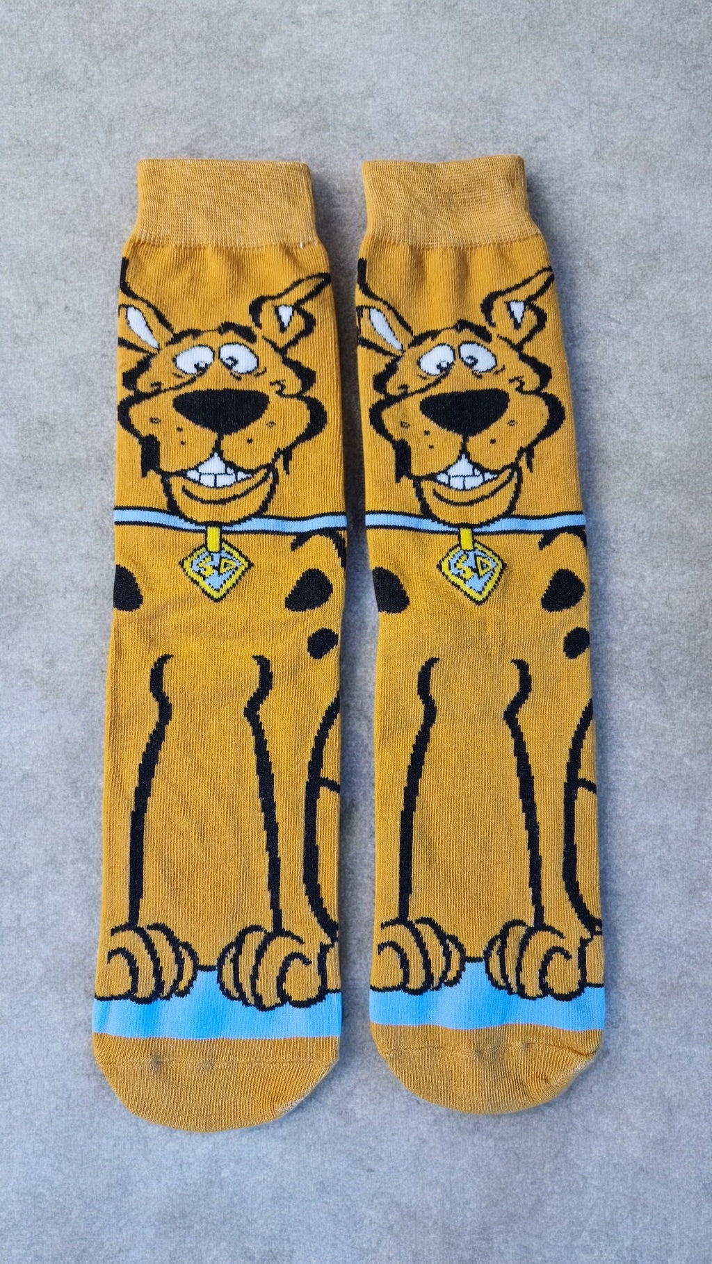 Pair of yellow socks with a cartoon character on a gray background