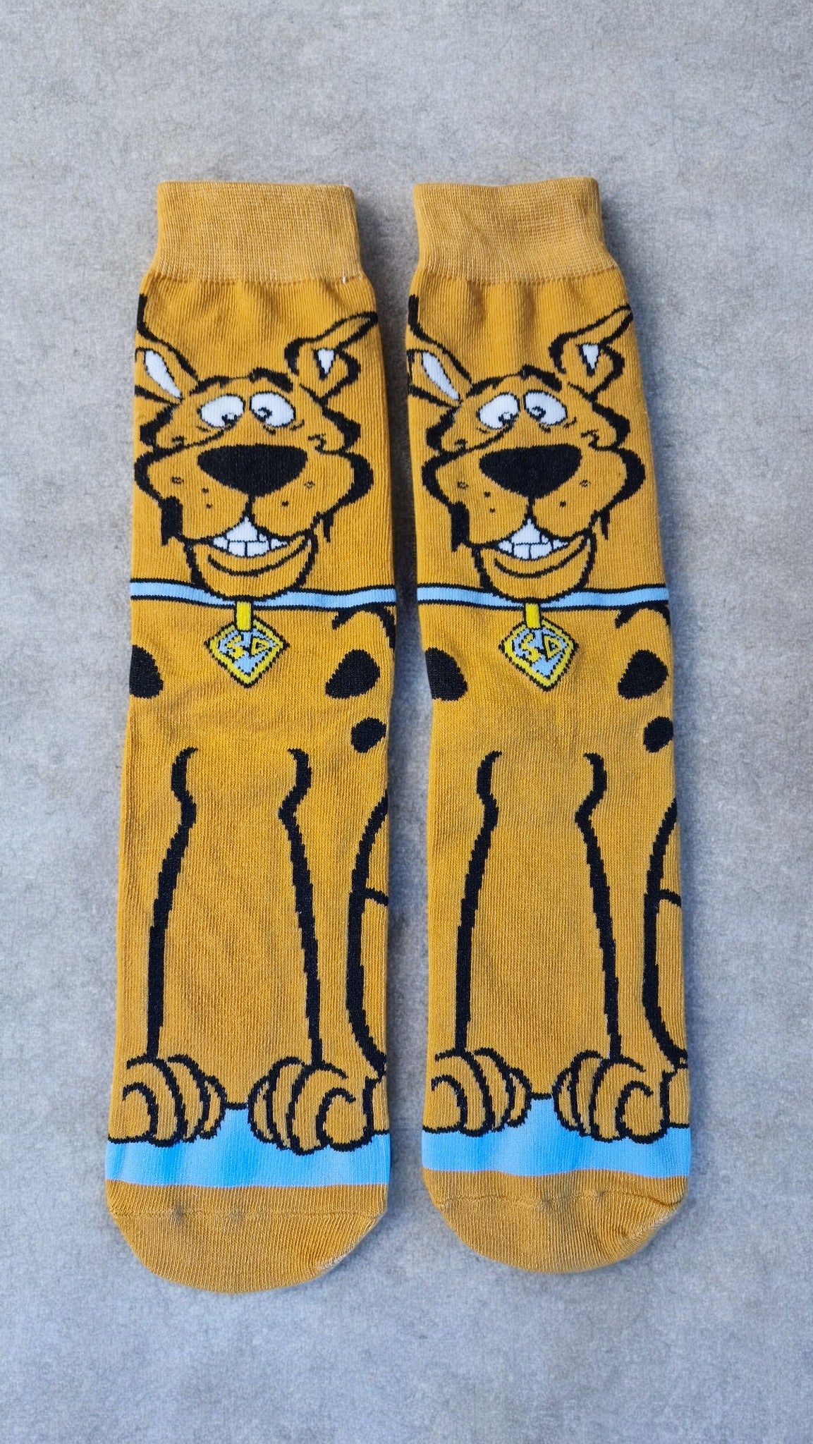 Pair of yellow socks with a cartoon character on a gray background