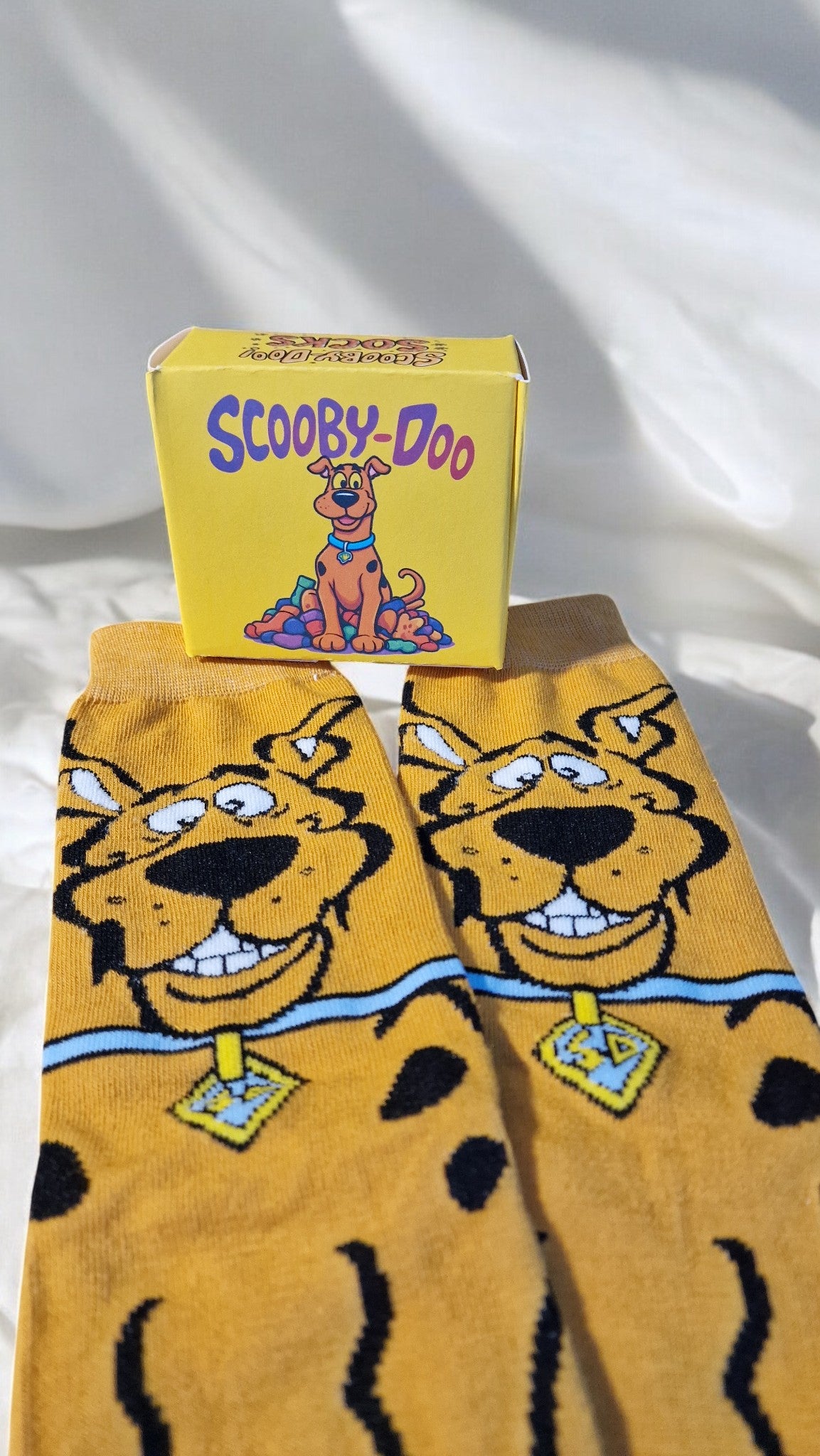 Scooby-Doo themed socks with a matching box on a white background