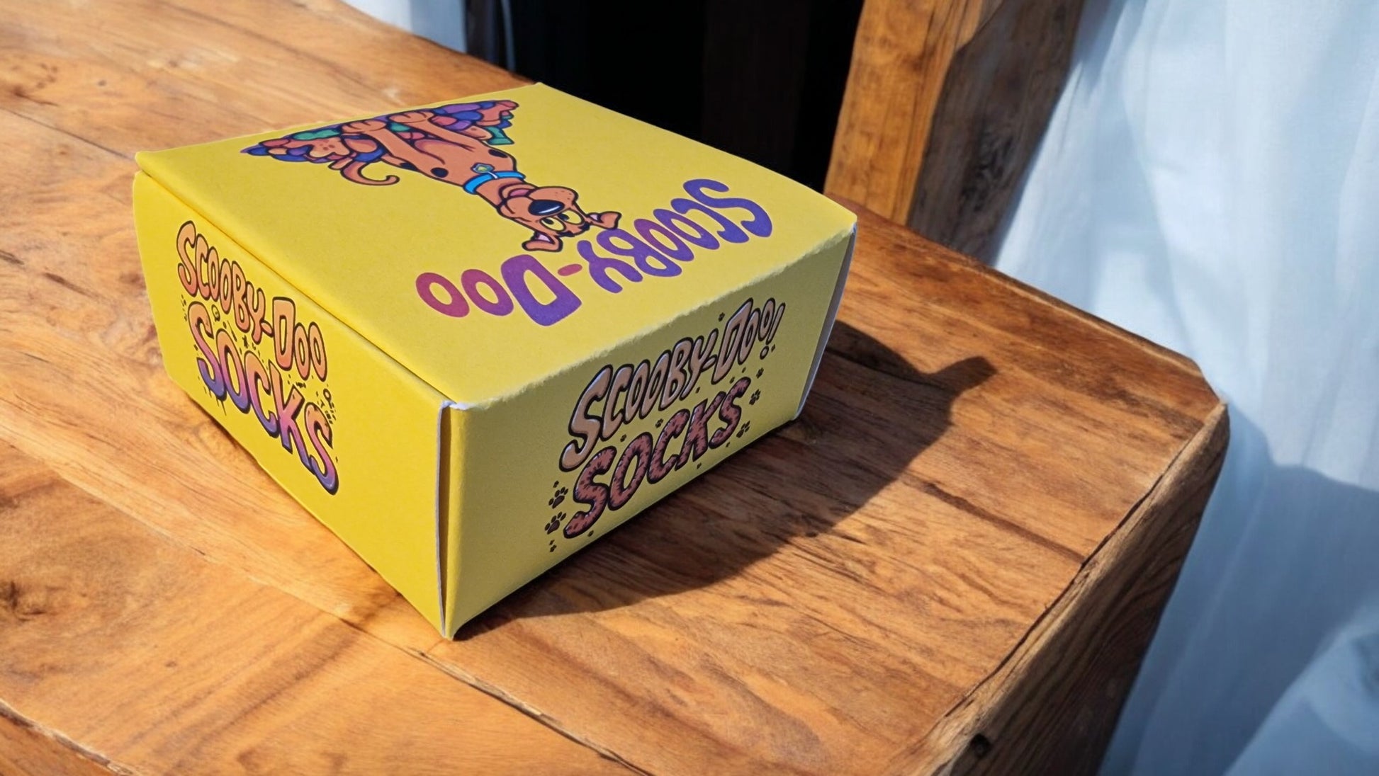 Yellow box with colorful text and graphics on a wooden surface