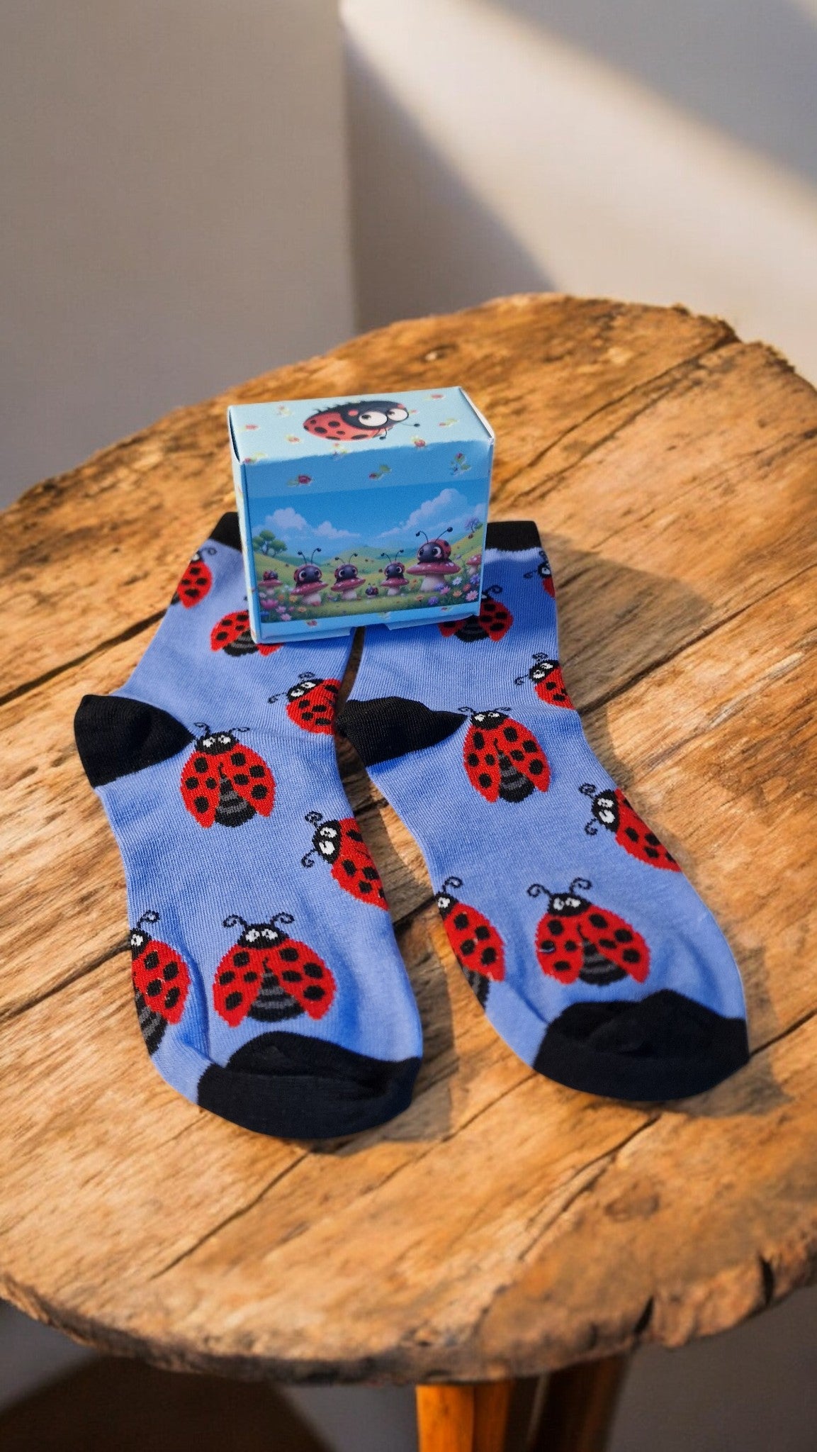 Blue socks with ladybug pattern on a wooden surface