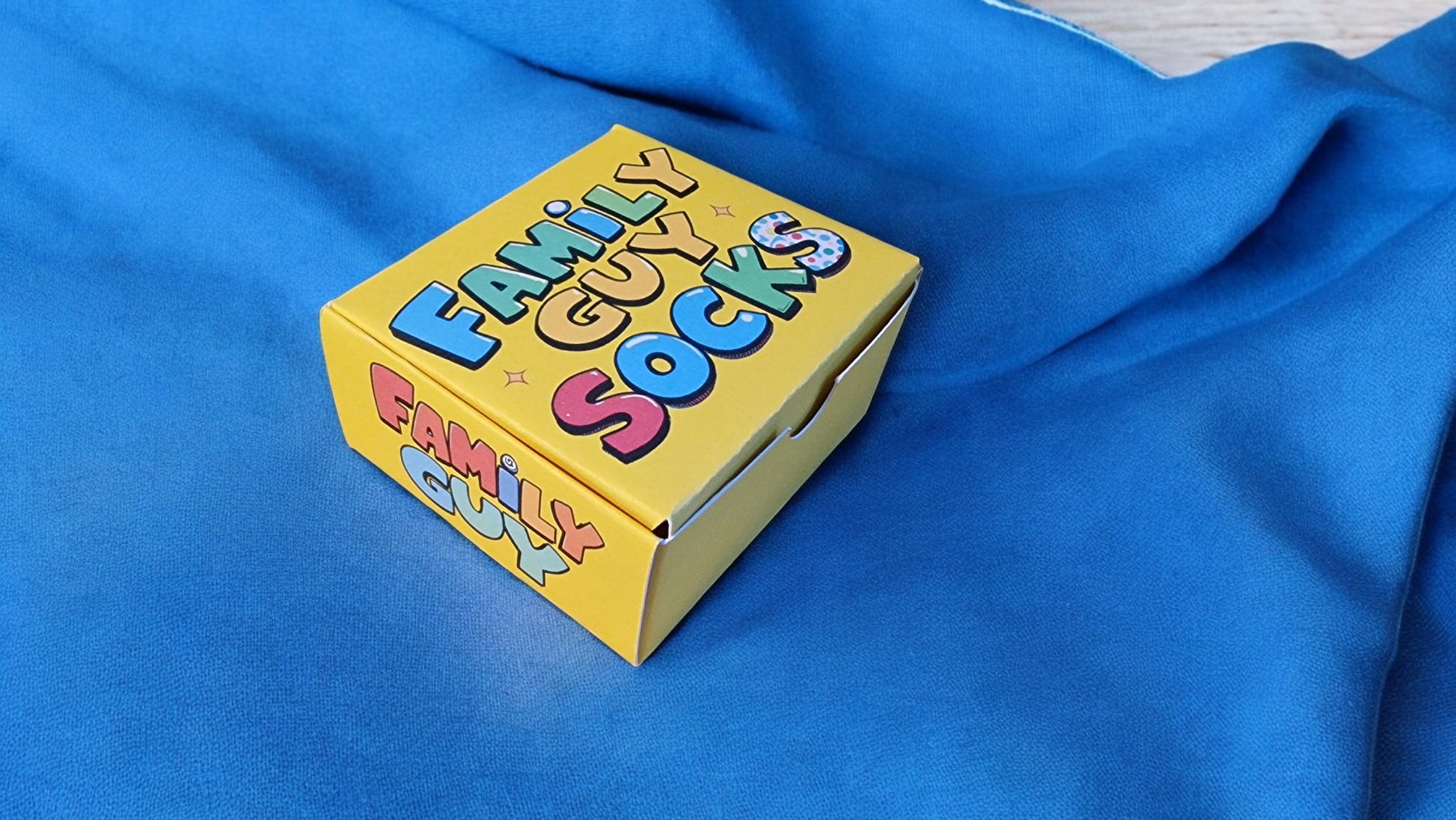 Yellow box labeled 'Family Guy Socks' on a blue fabric background