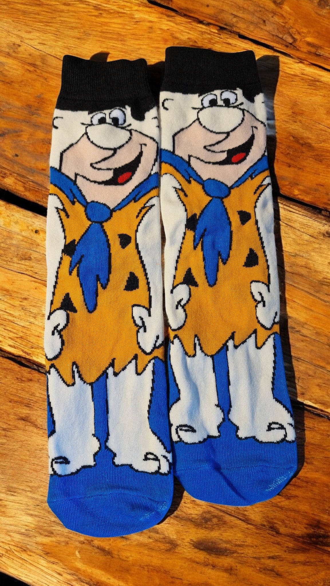 Pair of socks with cartoon character design on a wooden surface