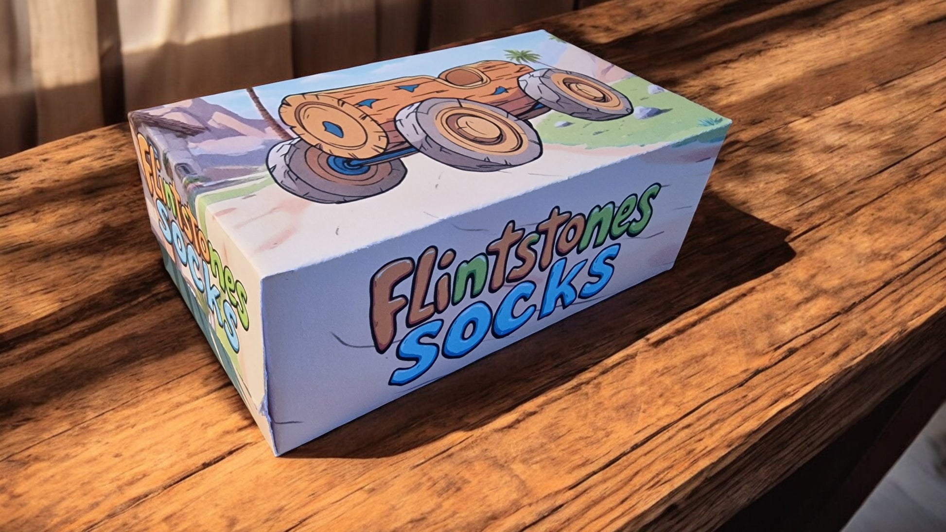 Box of Flintstones socks on a wooden surface