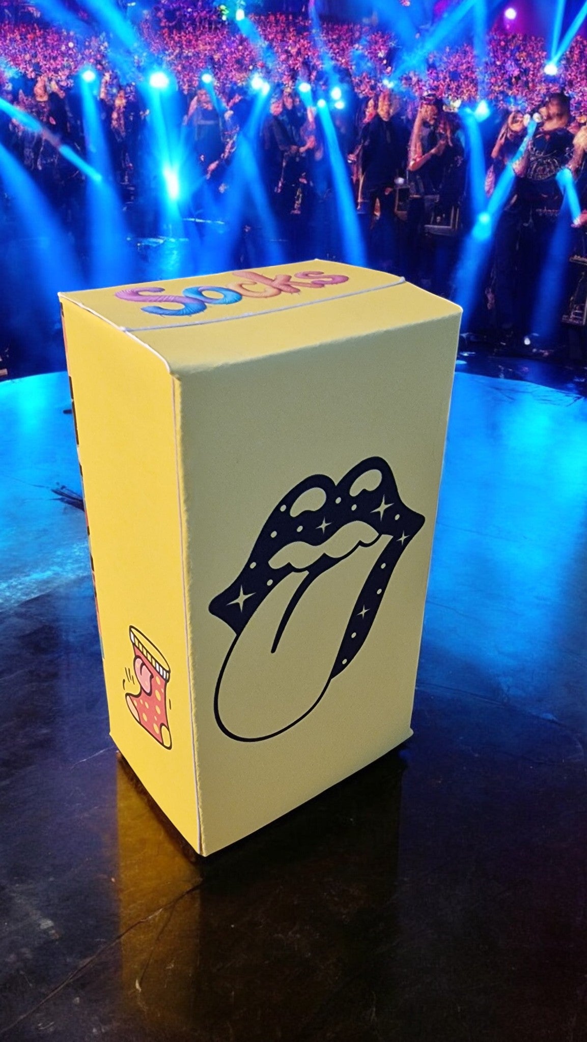 Yellow box with Rolling Stones logo on a stage with blue lights