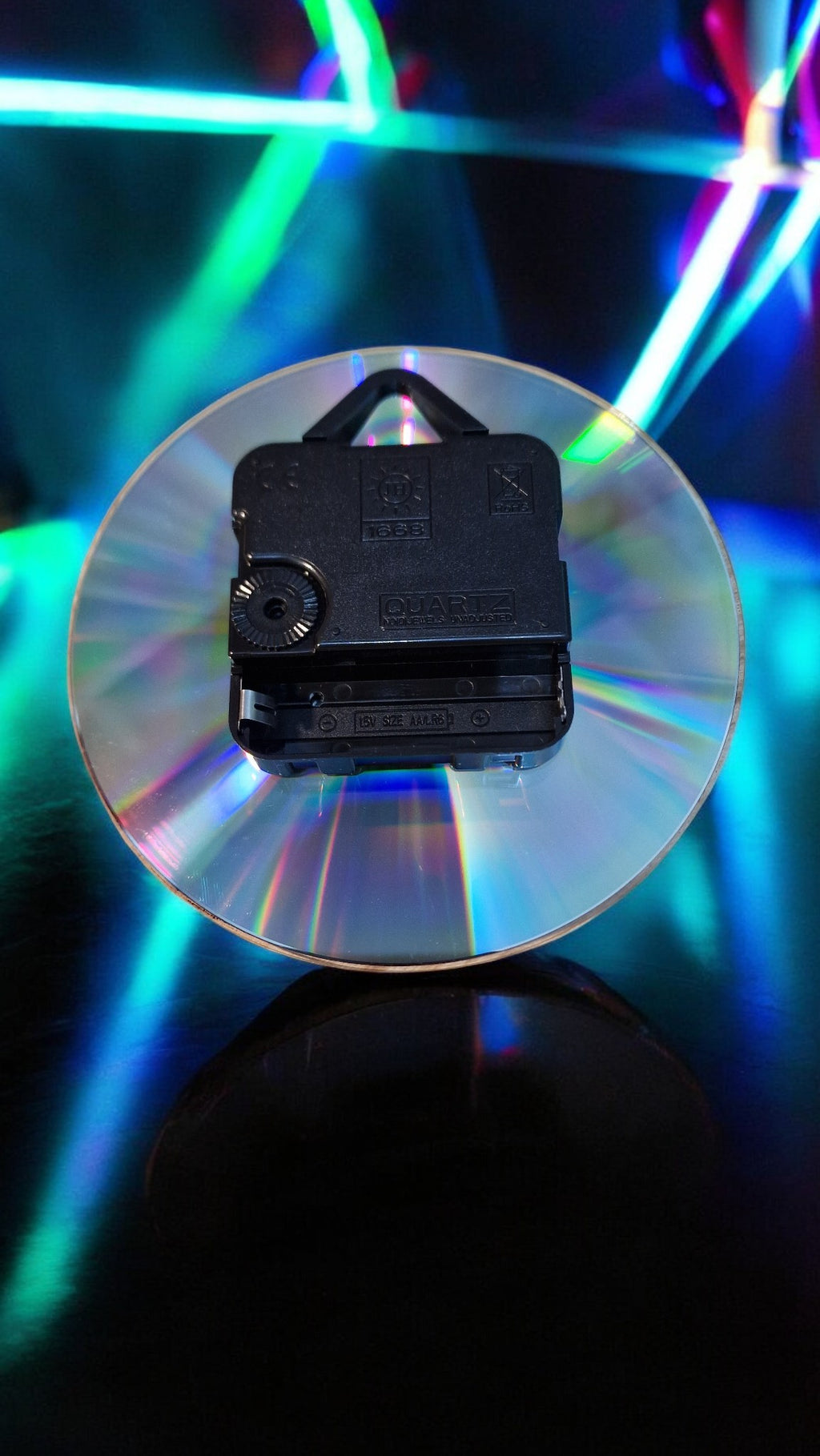 Small electronic device on a reflective surface with colorful lights in the background