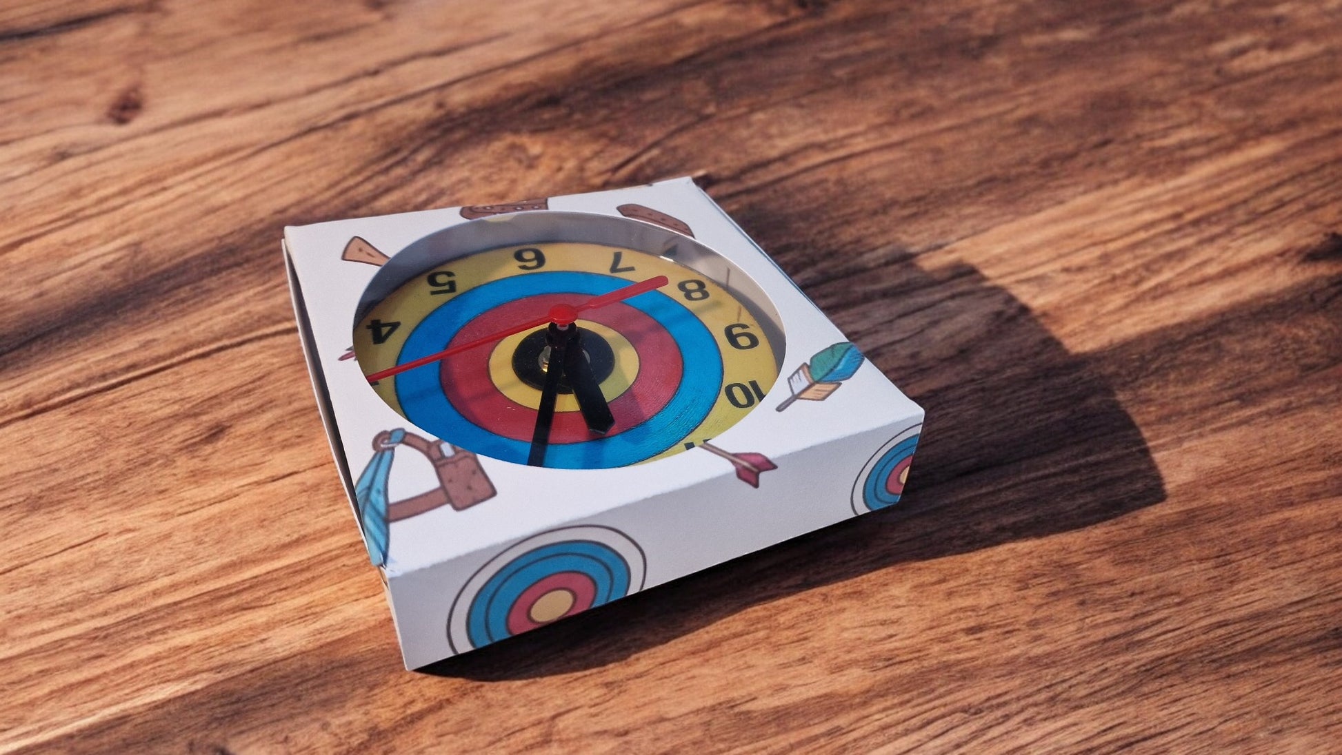 Dartboard-themed product packaging on a wooden surface