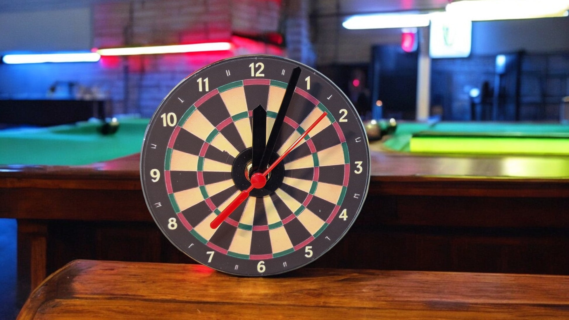 Dartboard clock on a pool table with a blurred background