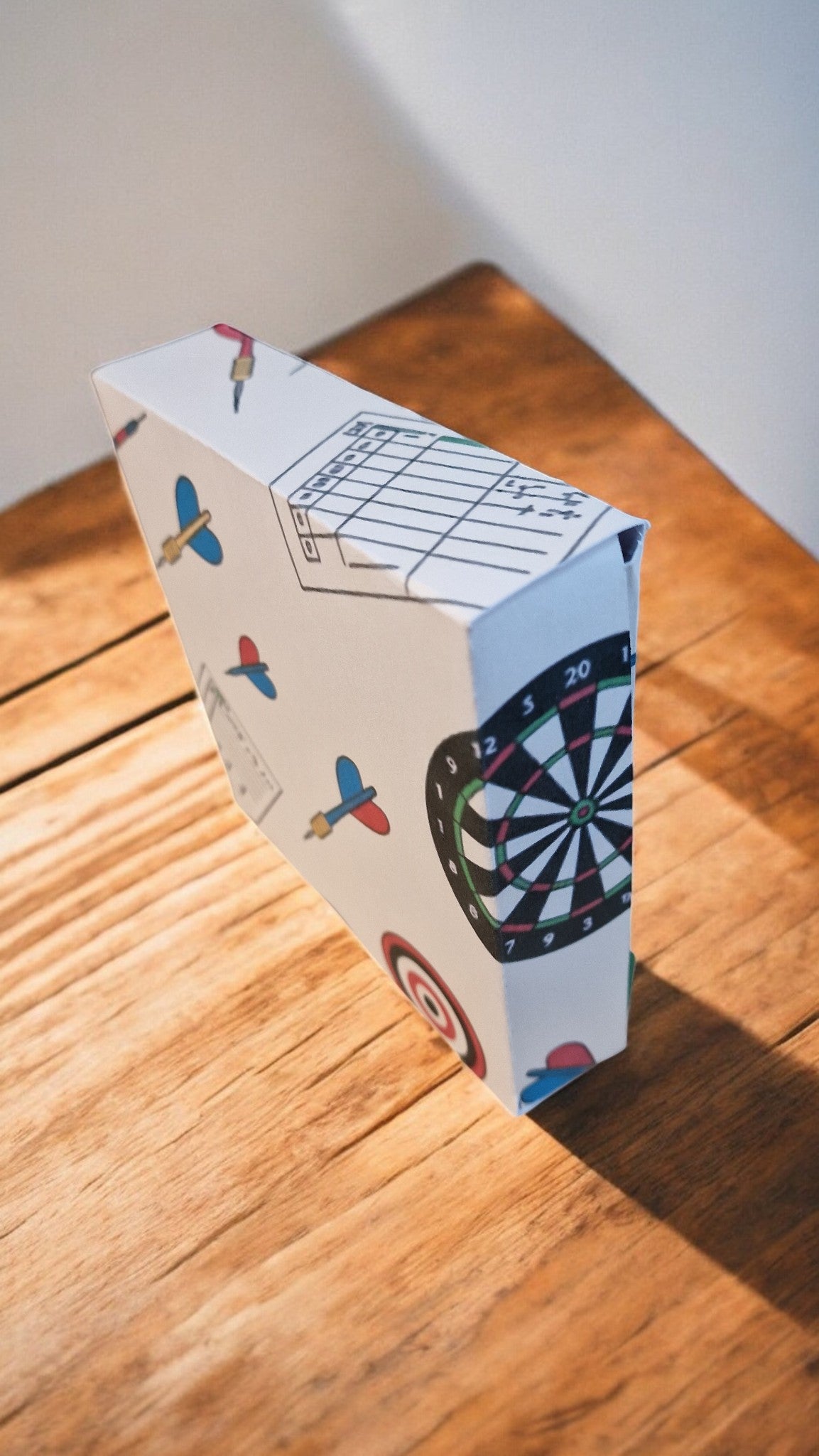 Cardboard box with a dartboard design on a wooden floor