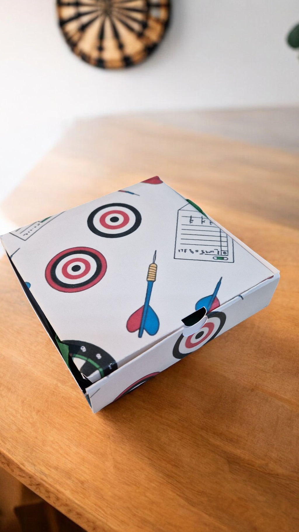 Box with dartboard and dart design on a wooden surface