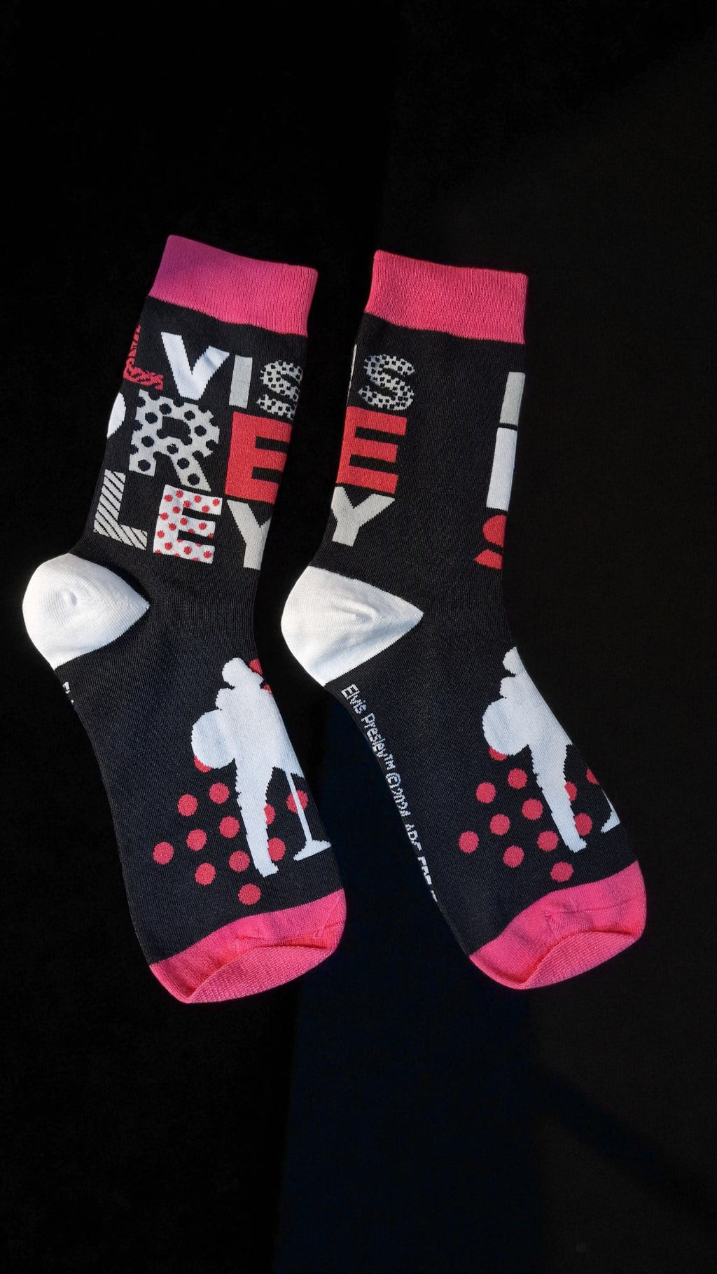 Two socks with colorful designs on a black background
