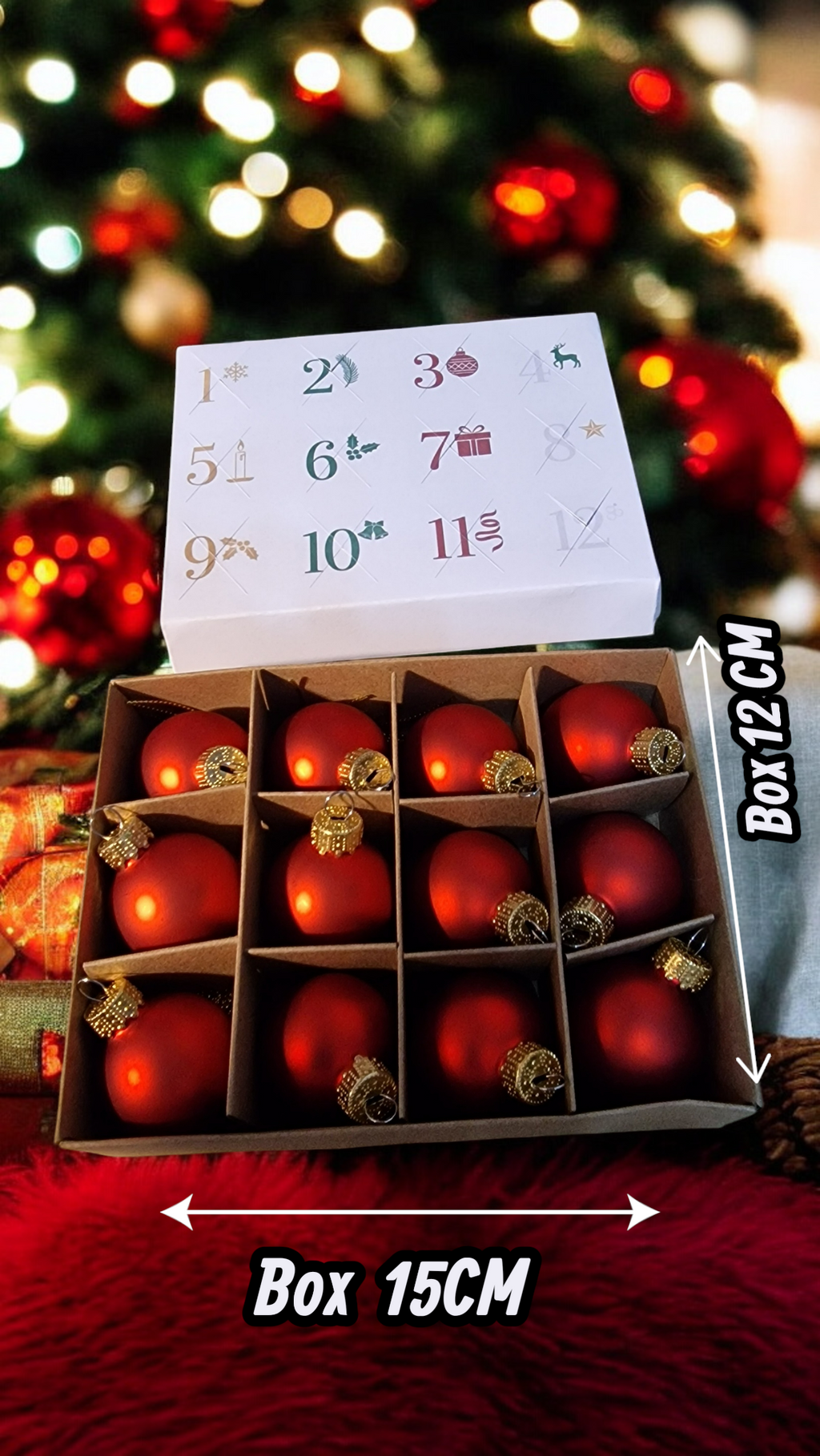 Box of red Christmas ornaments with a calendar on top, against a blurred Christmas tree background.