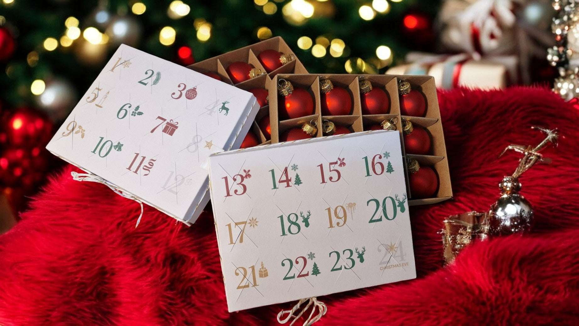Advent calendar with red balls on a red surface with blurred Christmas tree in the background