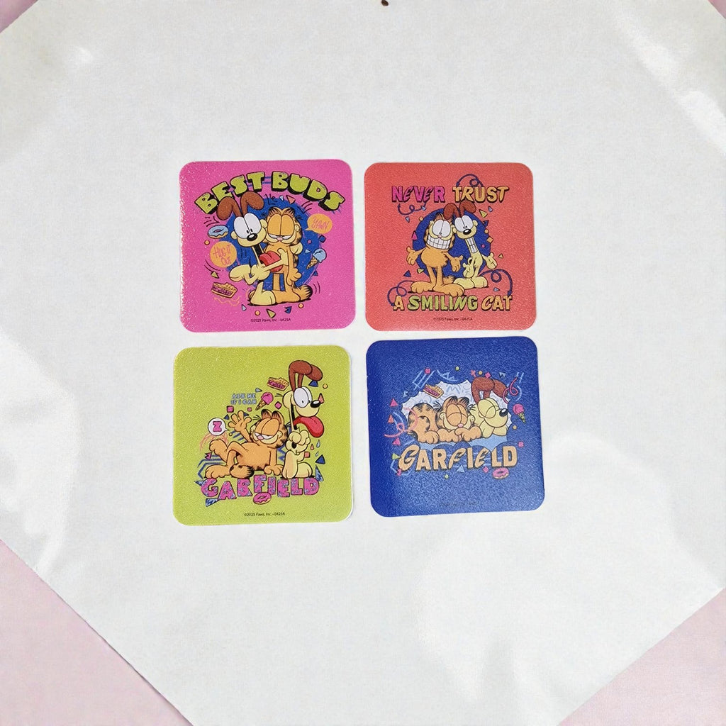 Four colorful coasters with Garfield cartoon characters on a white surface.