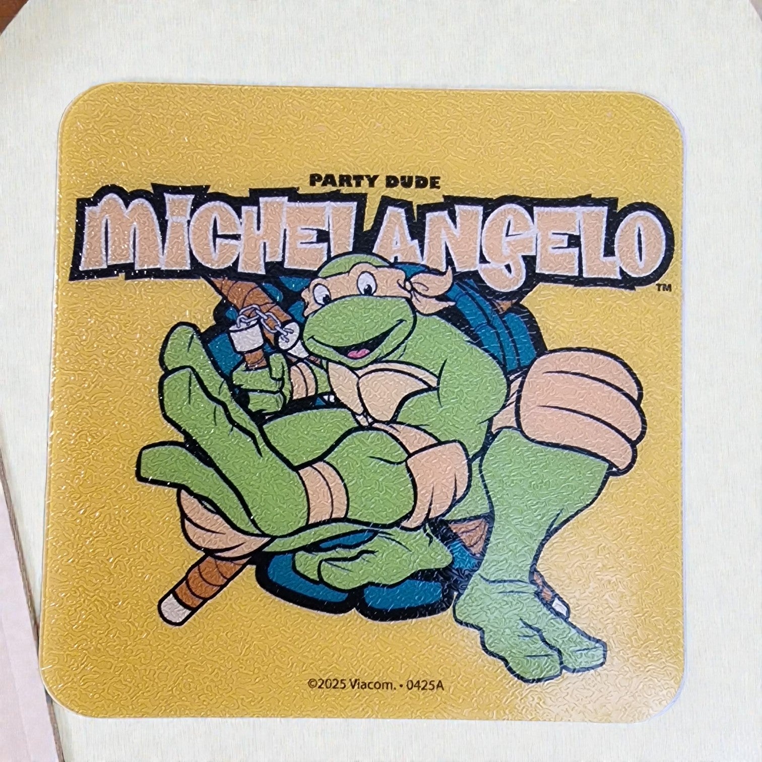 Coaster with cartoon turtle character and 'Michelangelo' text on a yellow background
