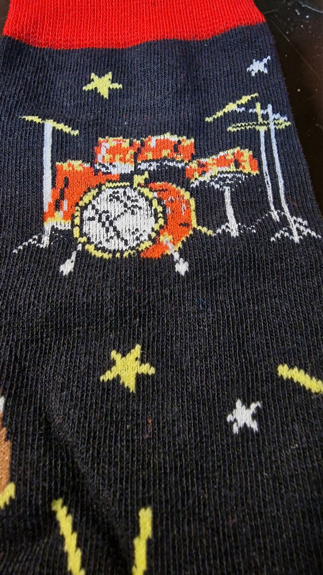 Socks with a drum set design and stars on a black background