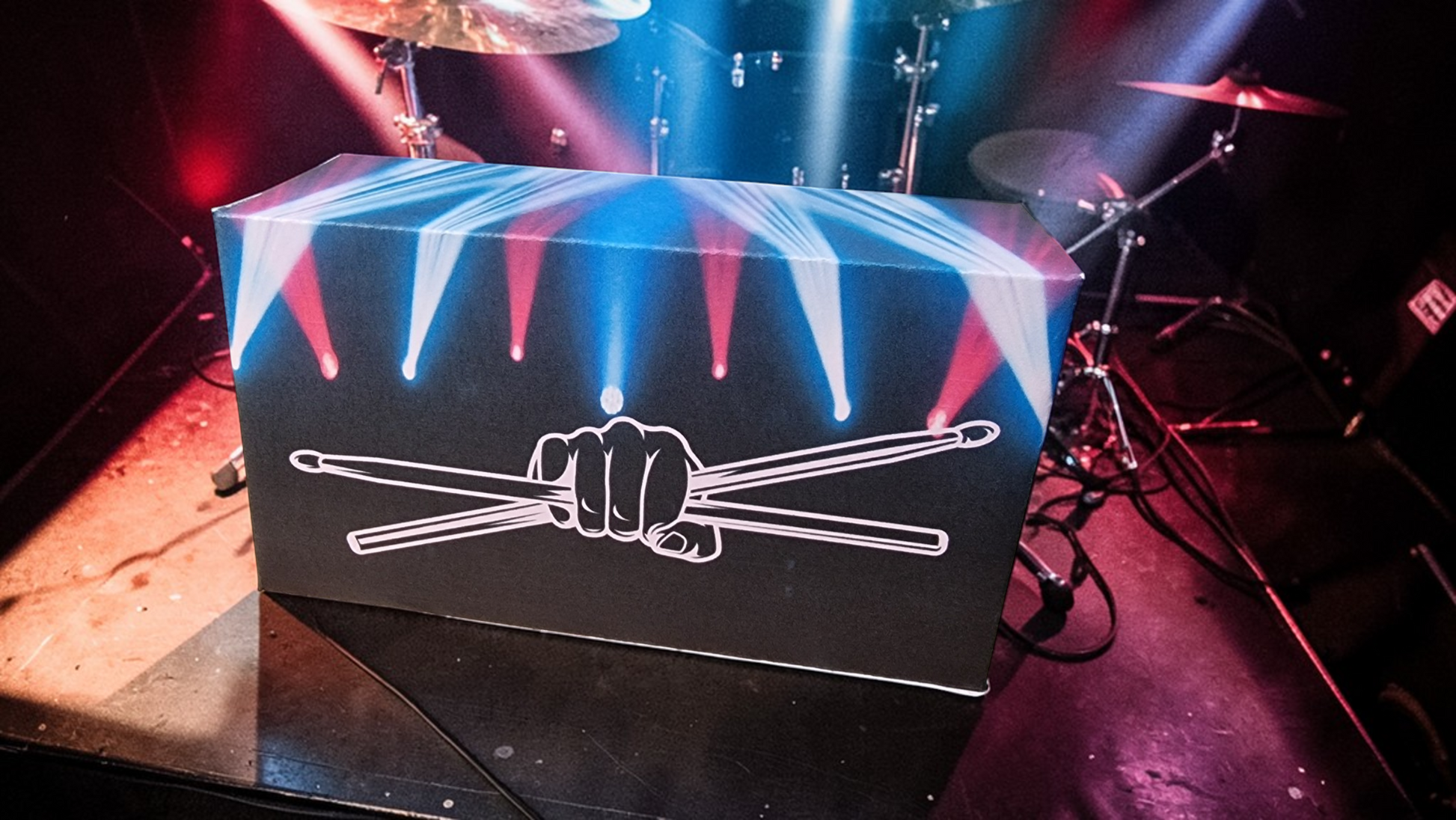 Box with drumstick design on a stage with musical equipment